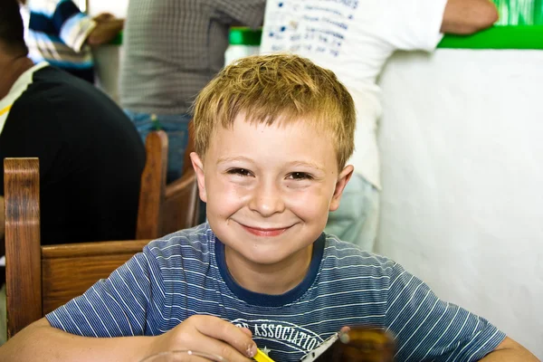 Na objednávku v restauraci čeká usměvavý chlapec — Stock fotografie