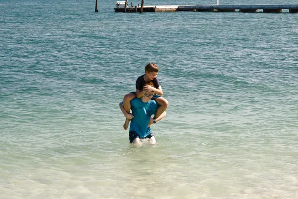 Hermanos están jugando juntos en un hermoso mar con cl cristal —  Fotos de Stock