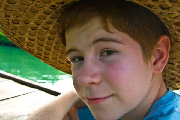 Niño lleva un sombrero de bambú durante un viaje en barco — Foto de Stock