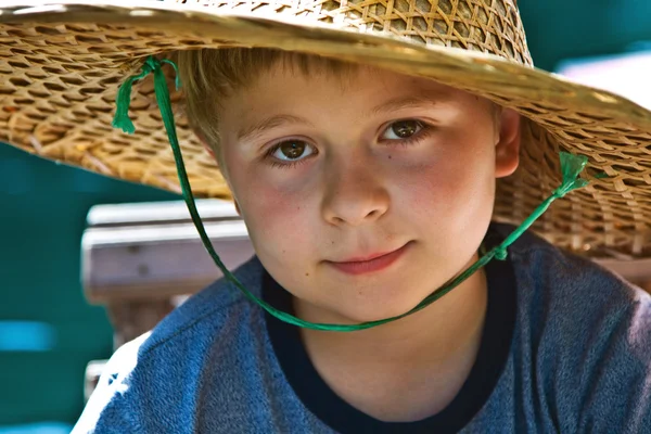 Kind is het dragen van een hoed gemaakt van bamboe tijdens een boottocht — Stockfoto