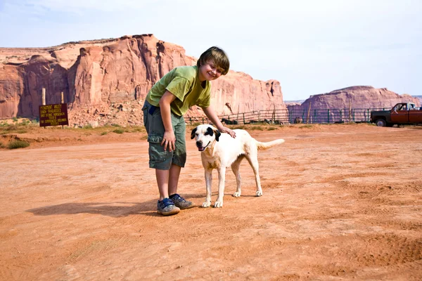 stock image Monument Valley, boy strokes a beautiful lovely dog in the lands