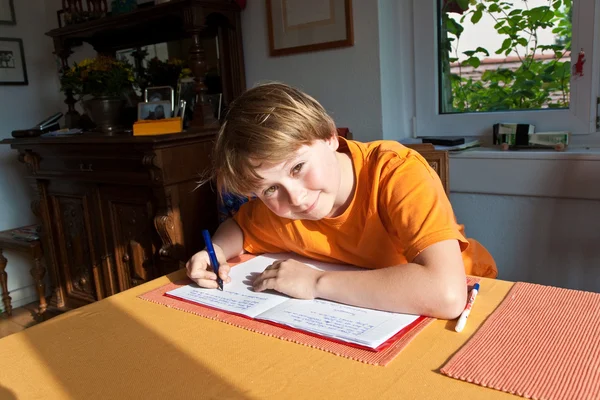 Мальчик делает домашнее задание для школы на дому — стоковое фото
