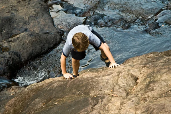 Chico subiendo por una roca —  Fotos de Stock