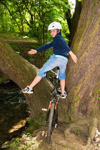 Мальчик в шлеме едет на горном велосипеде — стоковое фото