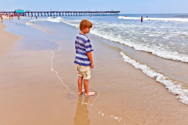 Хлопчик гуляє на пляжі — стокове фото