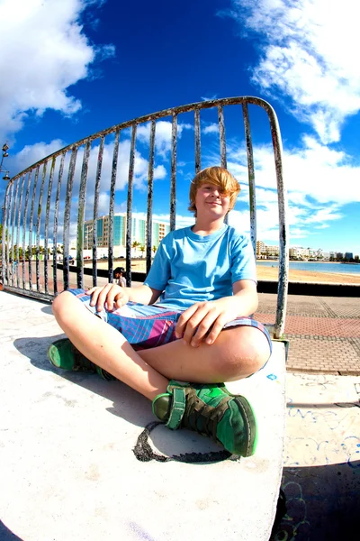 Симпатичный мальчик сидит в скейт-парке — стоковое фото