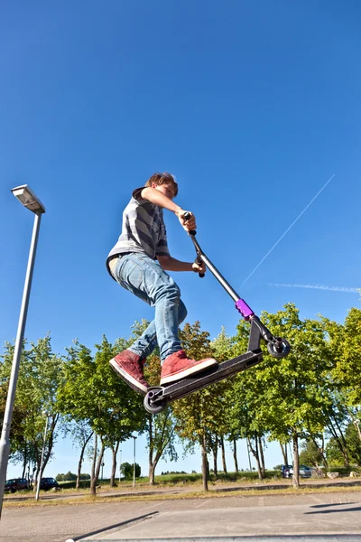 Fiú ugrik az ő robogó, a skate park — Stock Fotó