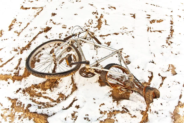 Littered and rusty bicycle as trash on snow — Stock Photo, Image