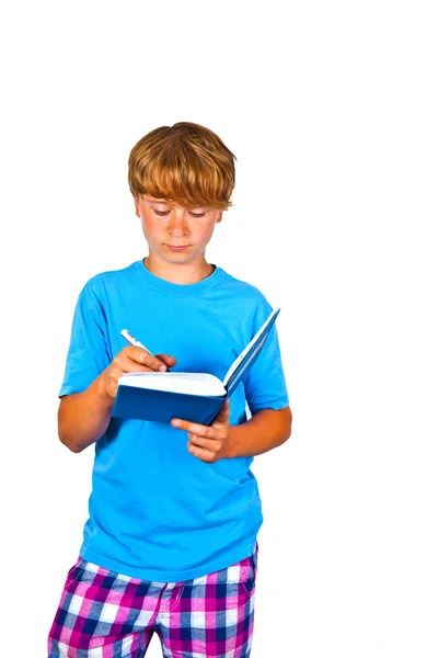 可爱的男孩在一本书里写作 — 图库照片