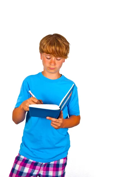 可爱的男孩在一本书里写作 — 图库照片
