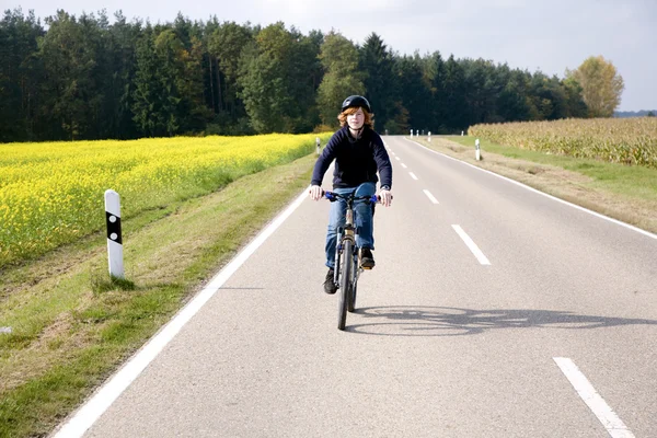 Niño en su bicicleta de montaña está en un recorrido en bicicleta a lo largo de beauti — Foto de Stock