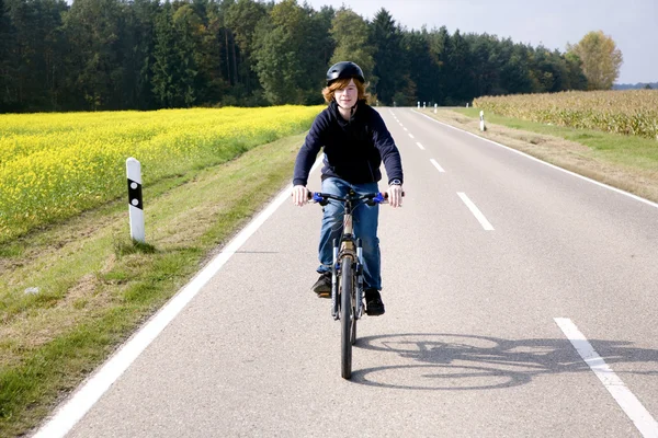 stock image Young boy on his mountain bike is on a bicycle tour along beauti