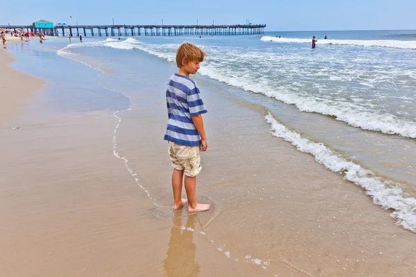 Мальчик гуляет по пляжу — стоковое фото