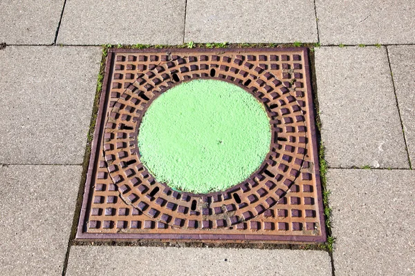 A manhole cover in the street to enter the canalisation — Stock Photo, Image