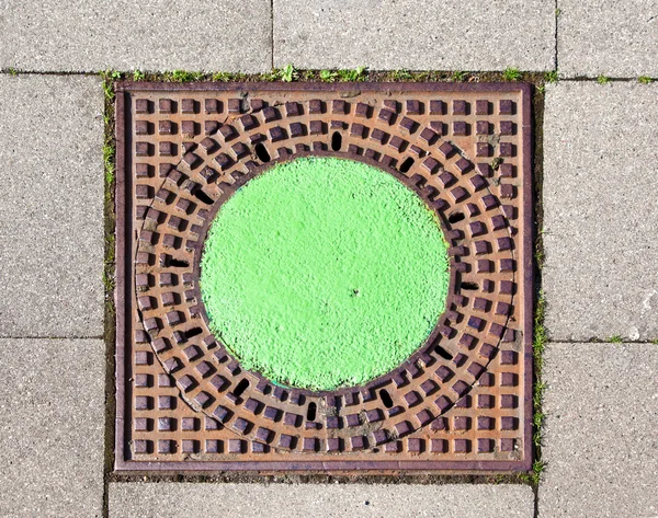 A manhole cover in the street to enter the canalisation — Stock Photo, Image