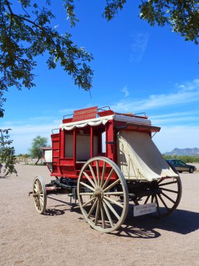 Red wooden stagecoach in open area without horses clipart