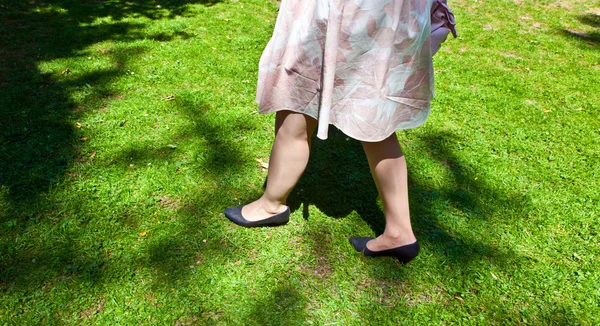 Πόδι του όμορφη κοπέλα περπάτημα στο πράσινο — Φωτογραφία Αρχείου