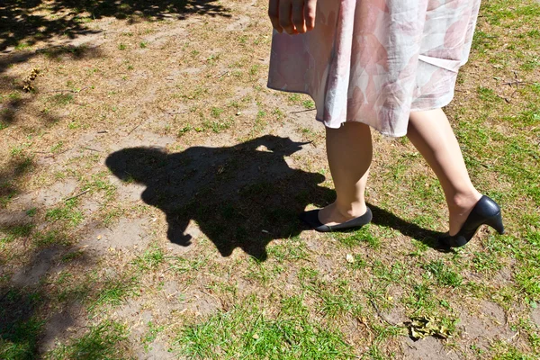 Pierna de hermosa chica caminando sobre el verde —  Fotos de Stock