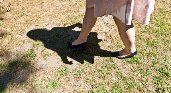 Perna de menina bonita andando sobre o verde — Fotografia de Stock