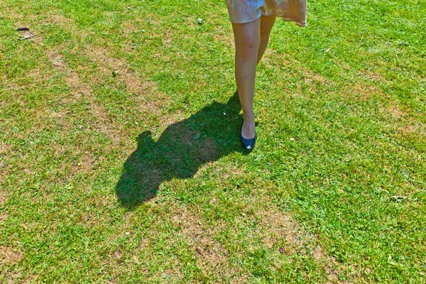 Нога красивой девушки, идущей по зеленому — стоковое фото