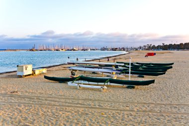 Scenic beach in Santa Barbara with boats in sunset clipart