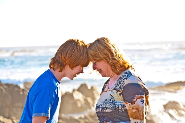 Mãe feliz e filho abraçando na praia — Fotografia de Stock
