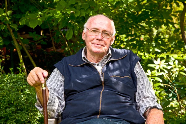 Retrato del anciano sentado feliz en su jardín —  Fotos de Stock