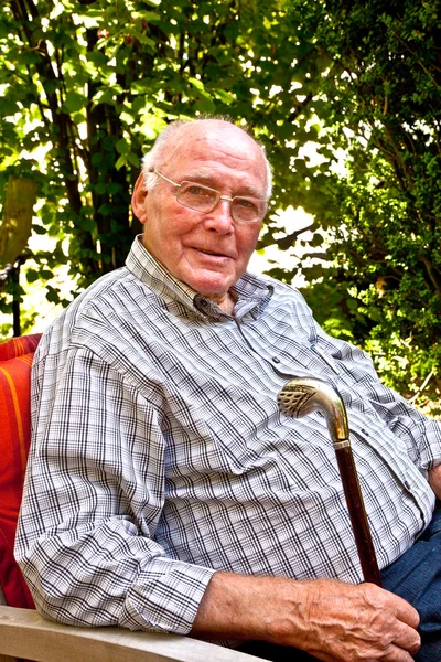 Счастливый пожилой человек в своем кресле в саду — стоковое фото