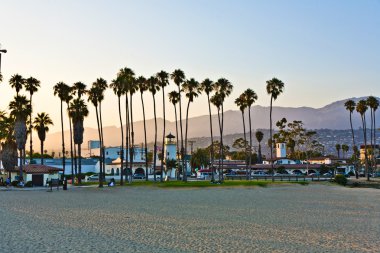 Scenic beach in Santa Barbara with palms in sunset clipart
