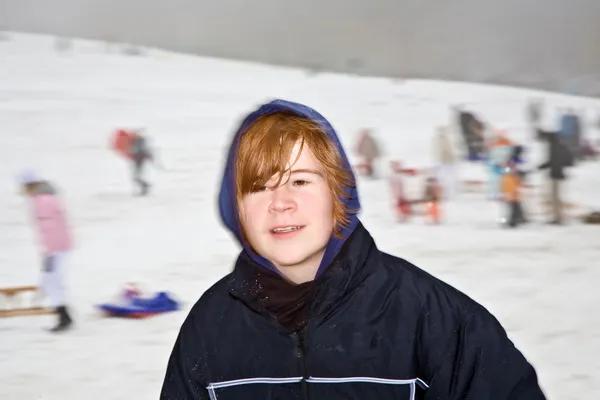 Junge sieht glücklich vom Spielen im Schnee und einer Schneeballschlacht aus — Stockfoto