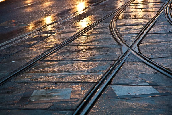 Trilhos carrinho molhado na luz e ruas estão refletindo luz — Fotografia de Stock