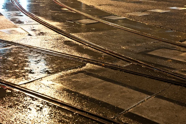 Wet trolley railes in the light and streets are reflecting light — Stock Photo, Image