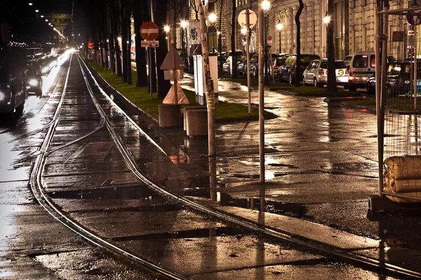 Мокрые трамвайные перила в свете и улицы отражают свет — стоковое фото