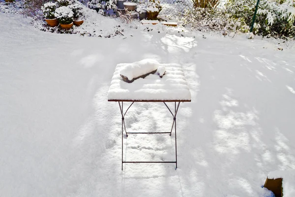 Sneeuw bedekte tabel in de tuin in de winter — Stockfoto