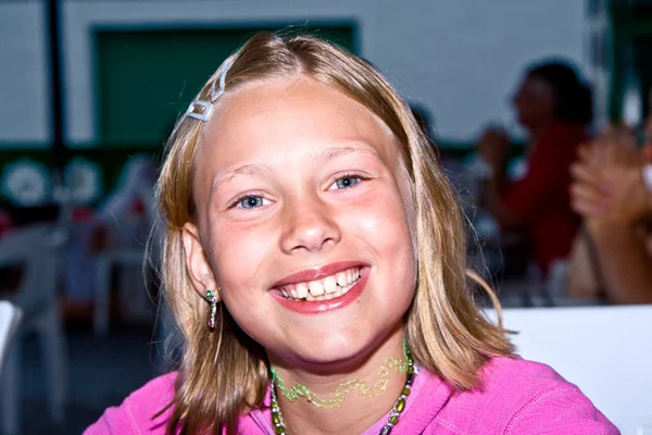 Happy girl smiles in a restaurant — Stock Photo, Image