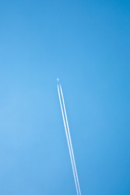 Condensation trail on blue sky clipart