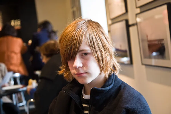 Boy with long red hair is looking critical — Stock Photo, Image