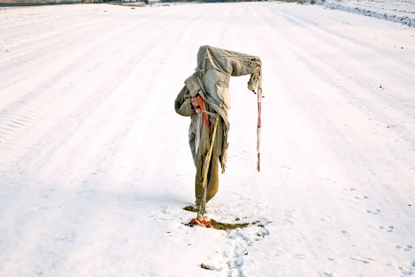 Smutne, obdarty i zamrożenie strach na wróble w zimie na snowfield — Zdjęcie stockowe