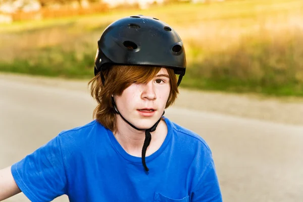 Niño está en bicicleta y con un casco, se toma un breve descanso — Foto de Stock
