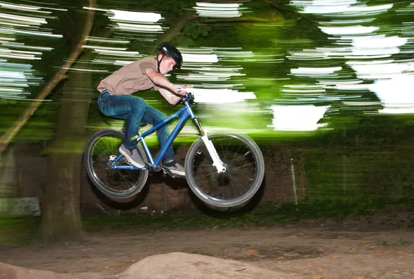 Child has fun jumping with the bike over a ramp — Stock Photo, Image