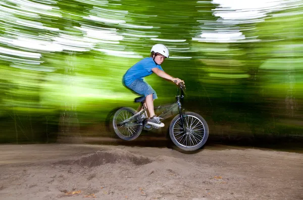 Child has fun jumping with the bike over a ramp — Stok fotoğraf