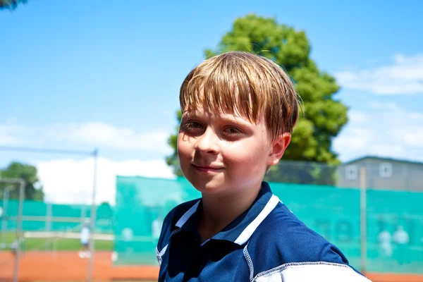 Dziecko wygląda szczęśliwy i zadowolony po meczu tenisa — Zdjęcie stockowe