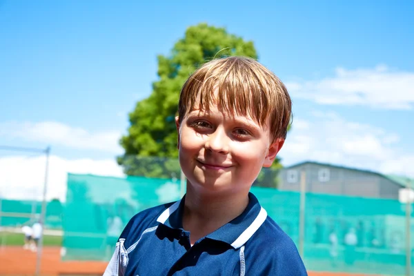 Child looks happy and satisfied after the tennis match — Stock Photo, Image