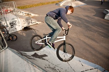 Boy riding his bike at the skatepark clipart