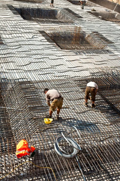 Arbeiter panzern die Bodenplatte eines Gebäudes mit Eisen — Stockfoto