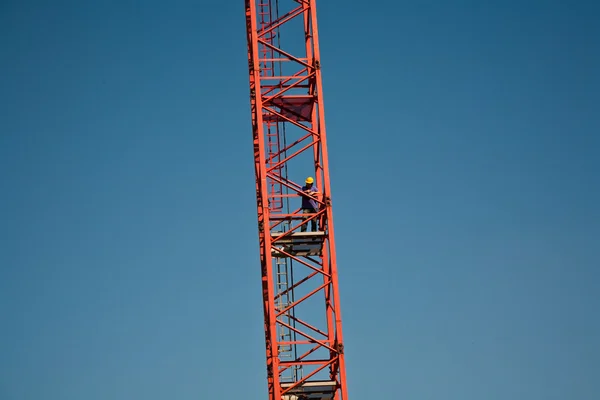 Чоловік піднімається на баштовий кран — стокове фото