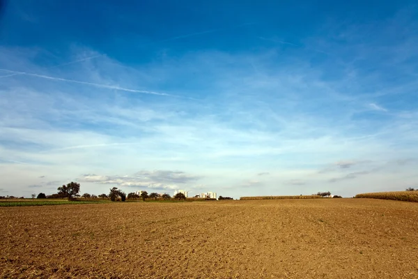 Campos recién arados con hermoso cielo azul en el horizonte —  Fotos de Stock