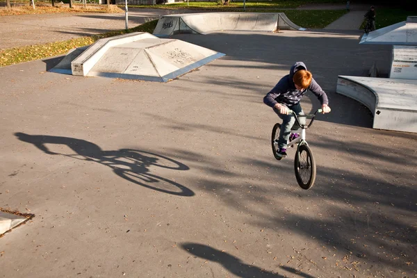 Ragazzo con i capelli rossi sta saltando con la sua BMX Bike allo skate park — Foto Stock