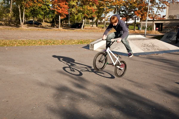 Мальчик с рыжими волосами прыгает на велосипеде BMX в скейт-парке — стоковое фото