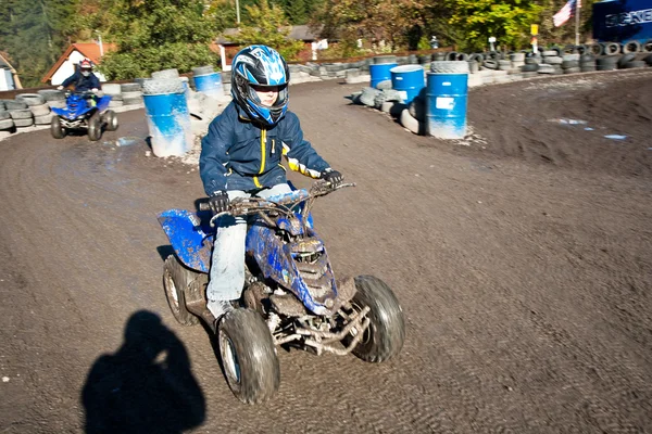 Child loves to race with a quad bike at the muddy quad track — Stock Photo, Image